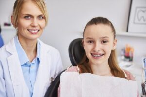 Orthodontist with a smiling young patient wearing braces